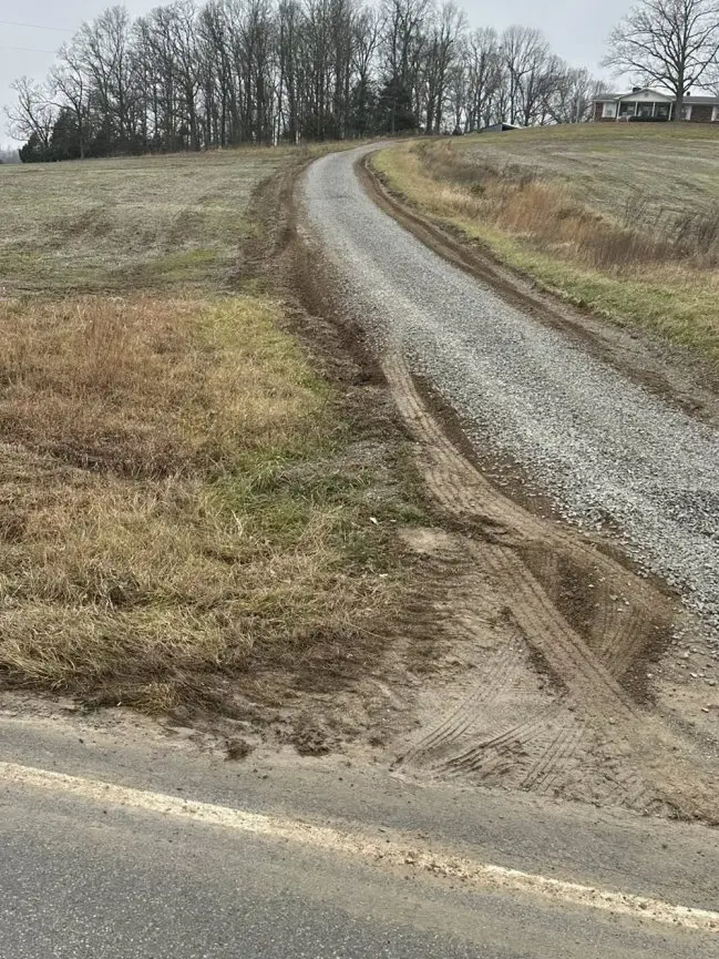SJ Perry Hauling job in APril 2026 after photo showing improved gravel covered driveway with large rock bordering edges